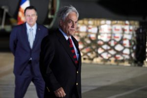 El presidente de Chile, Sebastián Piñera, camina frente a una de las remesas de ayuda humanitaria que será llevada hasta Venezuela desde Santiago (Chile). Fuente: EFE/Alberto Valdés.